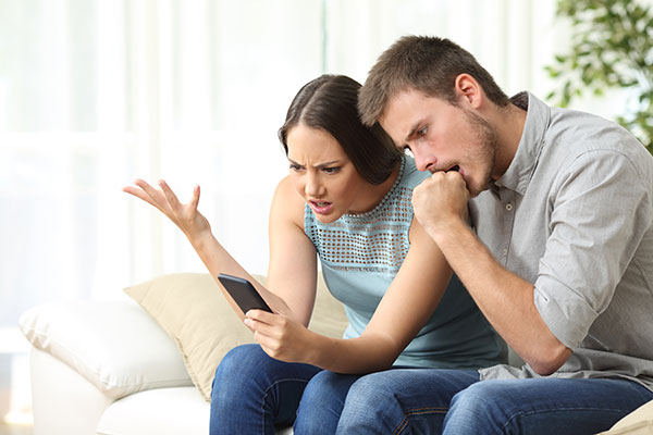 frustrated-couple-looking-at-phone